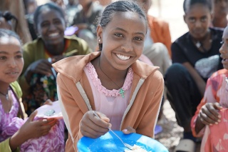 An image of a child eating their school meal looking happy